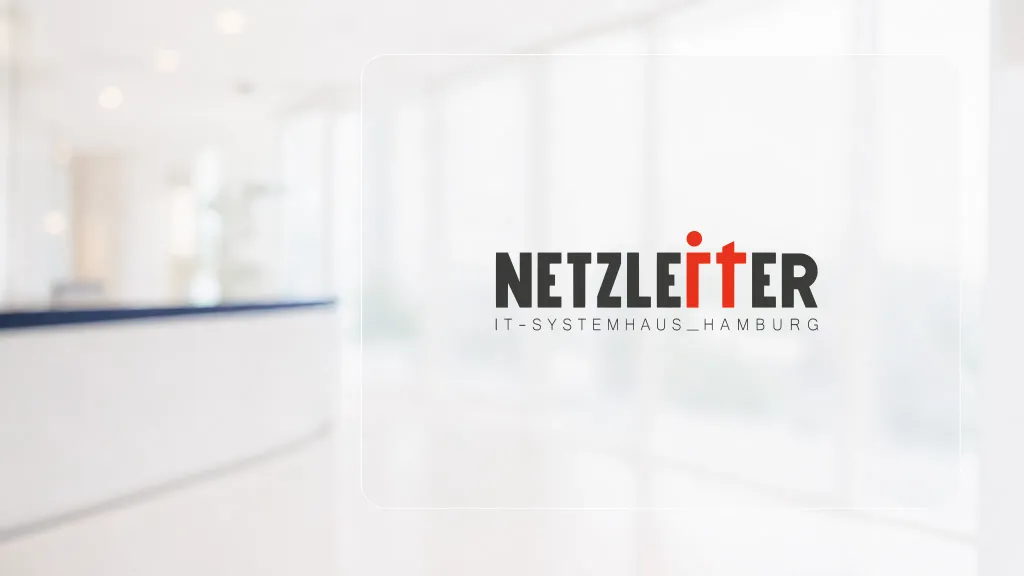 Unscharfer heller Praxisempfang mit dunkelblauer Tresenkante, davor eine transparente Glasfläche mit der Netzleiter-Wortmarke und dem Zusatz IT-Systemhaus Hamburg